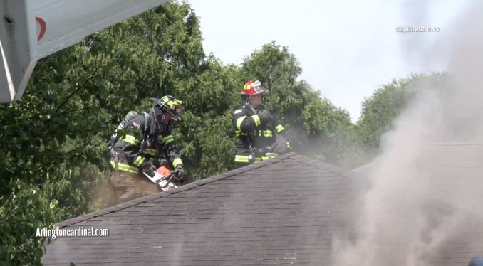 Firefighters on the roof of a home in Arlington Heights cut open the roof to vertically ventilate smoke and hot gas from the home on Tuesday, May 21, 2024 (CARDINAL NEWS)