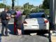 The driver and passenger speak with police after crashing into a building support at the Huntington Square strip mall on Rand Road near Hintz Road in Arlington Heights on Tuesday, June 11, 2024 (CARDINAL NEWS)