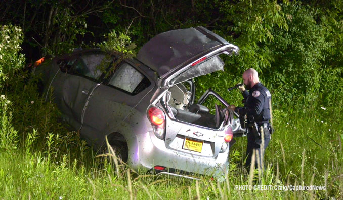 A police officer inspects the crash scene after a driver was extricated from a silver Chevy Spark on US-41 south of IL-60 in Lake Forest (Craig/CapturedNews)