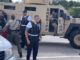 A female Illinois State Police trooper searches suspect Luisa Sanchez next to a Lake County Sheriff's Office armored vehicle on Route 14 immediately after her arrest at the Speedway gas station about 2:10 p.m. Tuesday, August 20, 2024 (CARDINAL NEWS)