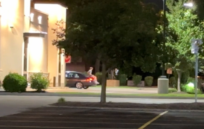 Reckless driver passes the front of Raising Cain's restaurant in Arlington Heights with a passenger on the vehicle's trunk on Monday, August 5, 2024 at 10:40 p.m. (CARDINAL NEWS)