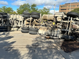 A semi-trailer dump truck on its side in the northbound lanes of Arlington Heights near Guitar Center at 2375 South Arlington Heights Road on Friday morning, September 6, 2024 (CARDINAL NEWS)