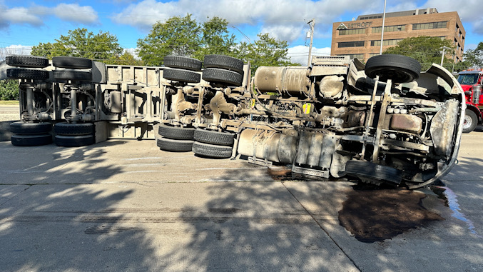 A semi-trailer dump truck  on its side in the northbound lanes of Arlington Heights near Guitar Center at 2375 South Arlington Heights Road on Friday morning, September 6, 2024 (CARDINAL NEWS)