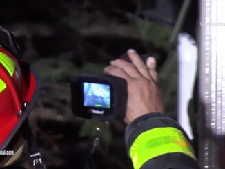 Arlington Heights fire lieutenant from Engine 4 uses a Thermal Image Camera to check for hot spots at the exterior of the attached garage wall (CARDINAL NEWS)