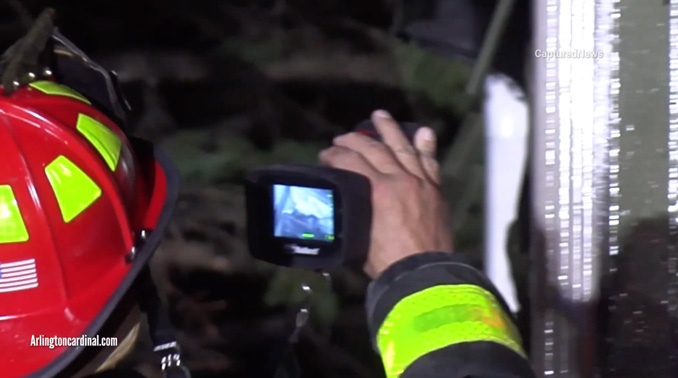 Arlington Heights fire lieutenant from Engine 4 uses a Thermal Image Camera to check for hot spots at the exterior of the attached garage wall (CARDINAL NEWS)