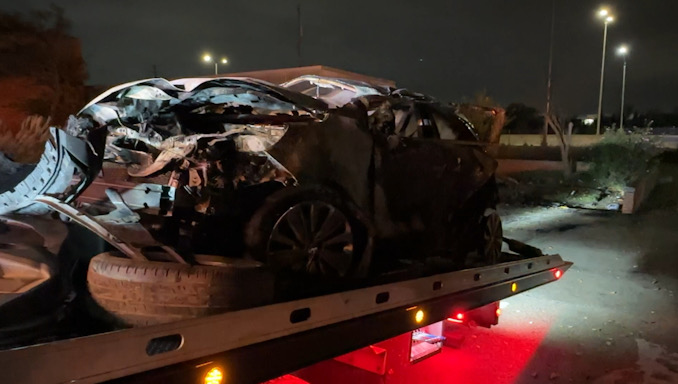 An Illinois State Police trooper rescued two dogs while this Buick was rolled on its passenger side and on fire at a commercial property near I-90 after it was rear-ended on I-90 by the driver of an Audi (CARDINAL NEWS)