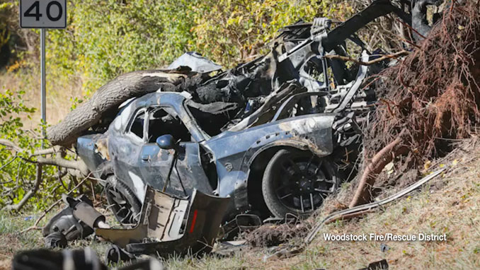 A 40 MPH Speed Limit sign visible in the background of a photo of the burnt wreckage of a black Dodge Challenger that was involved in a crash on Davis Road near southwest Woodstock in western Dorr Township in McHenry County (SOURCE: Woodstock Fire/Rescue District)