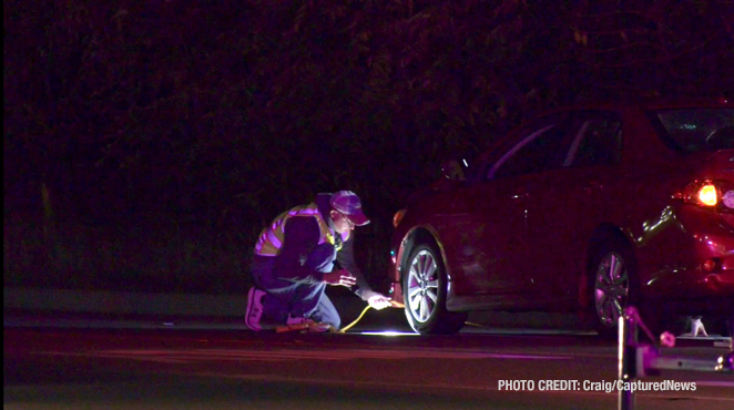 MCAT investigators examining the red 4-door sedan that remained at the scene after a fatal vehicle vs pedestrian crash on Friday night, October 18, 2024 (PHOTO CREDIT: Craig/CapturedNews)