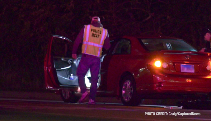 MCAT investigators examining the red 4-door sedan that remained at the scene after a fatal vehicle vs pedestrian crash on Friday night, October 18, 2024 (PHOTO CREDIT: Craig/CapturedNews)