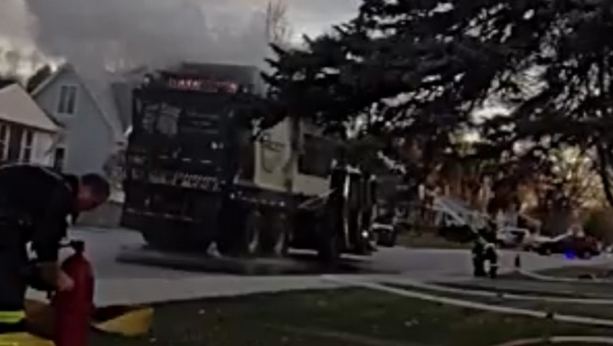 Firefighters hose line stream directed to the top of the Groot garbage truck near the position where the Compress Natural Gas (CNG)cylinders are located (SOURCE: Arlington Heights Police Department)